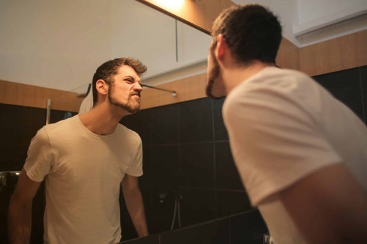 young-unshaven-man-looking-at-mirror-in-bathroom-3771064