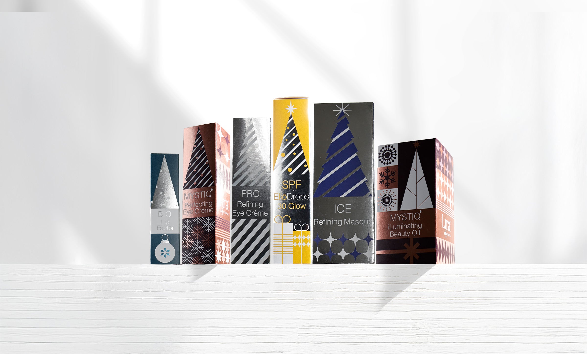 six boxes lined up white background, silver and bronze packaging