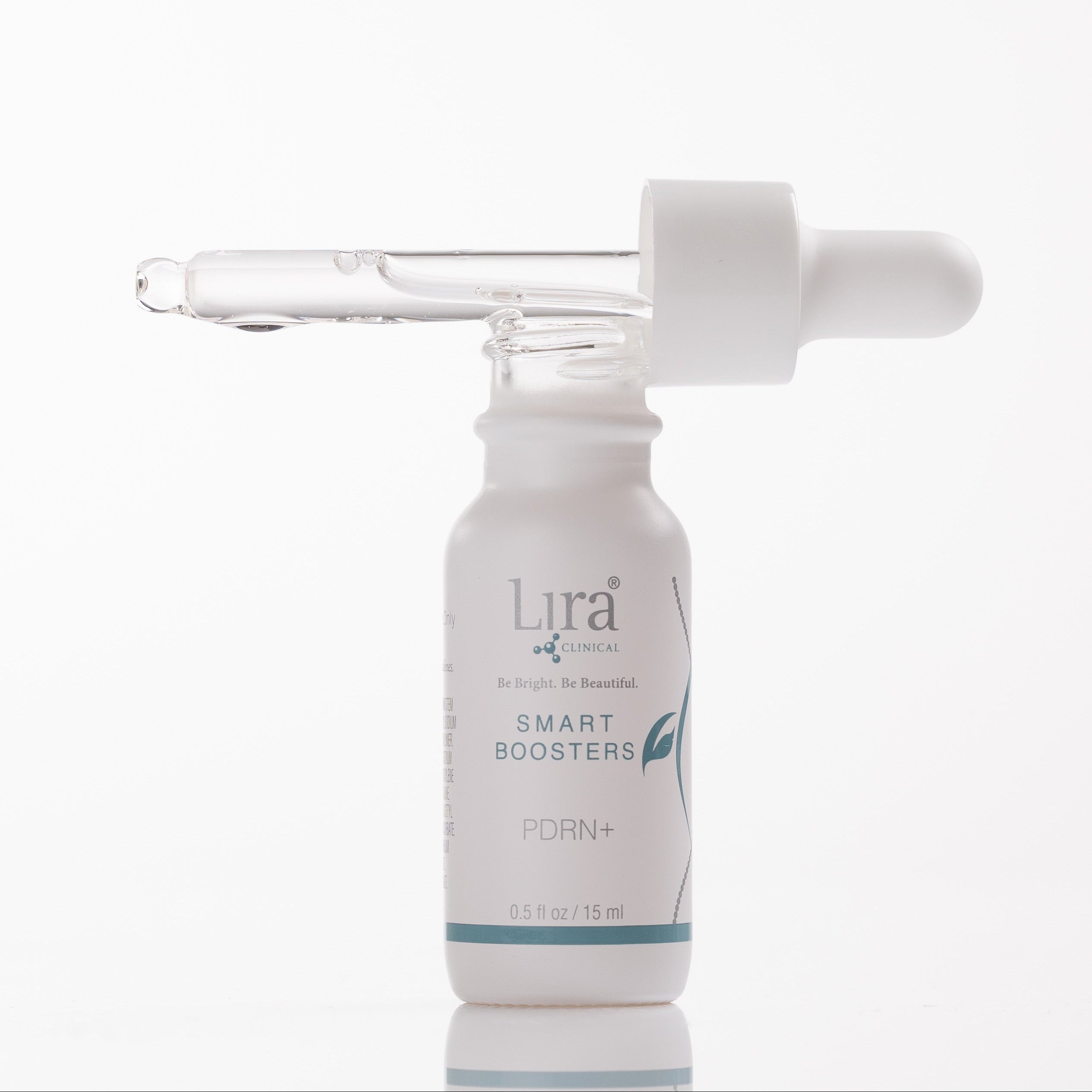 A white glass dropper bottle of Lira + Wellness Smart Boosters PDRN+ serum with a glass pipette resting horizontally across the open top, set against a seamless white background.